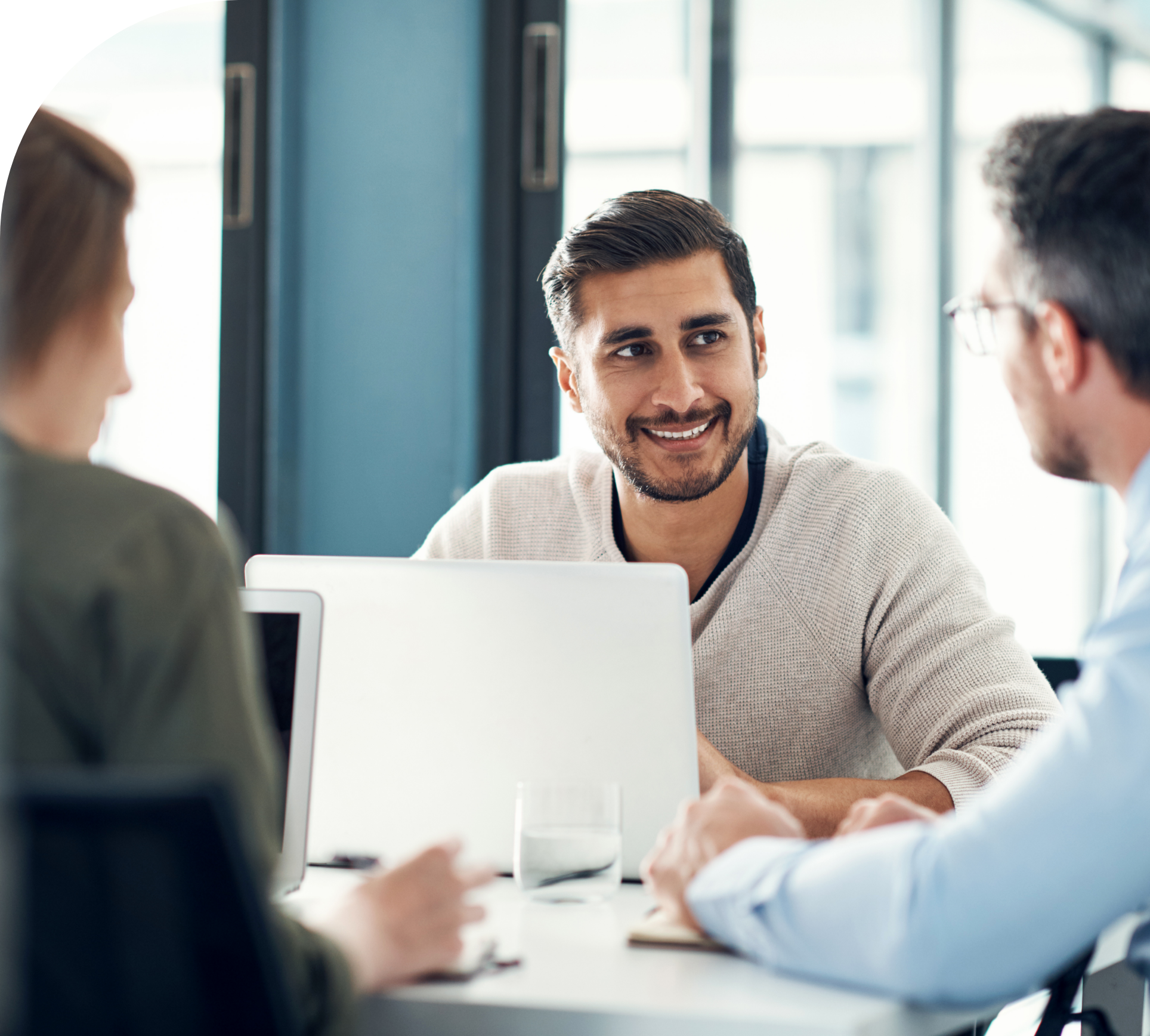 Man smiling and working with others.