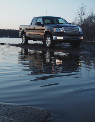 Truck next to water.