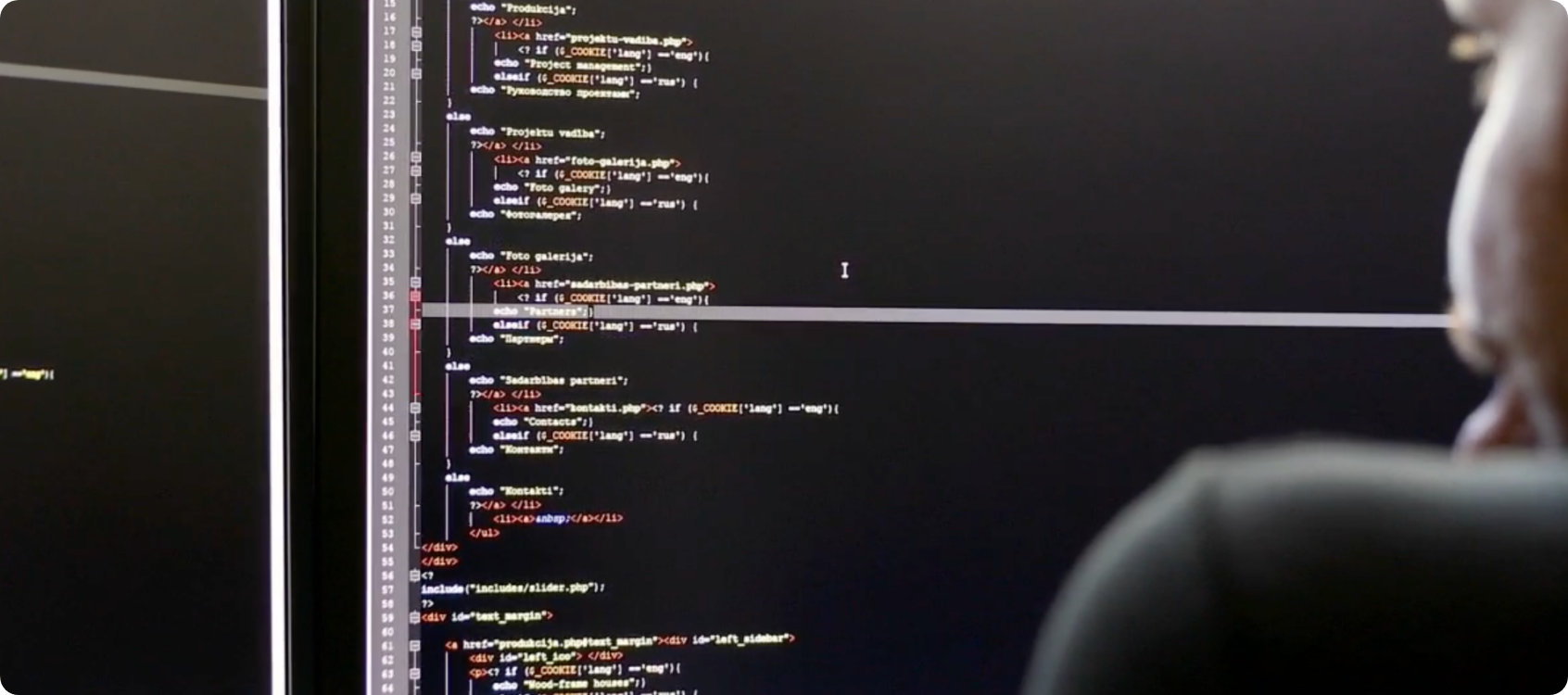 Man looking at screen with code.