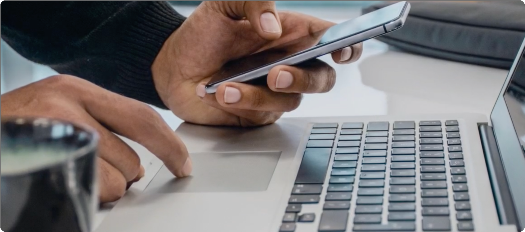 Person using computer and phone.