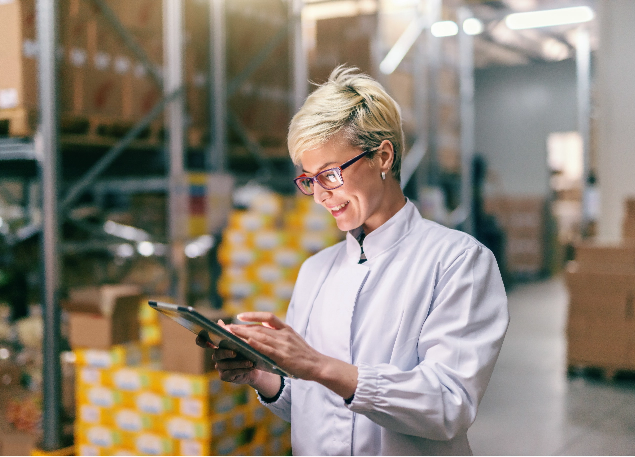 Woman in a warehouse using a tablet.