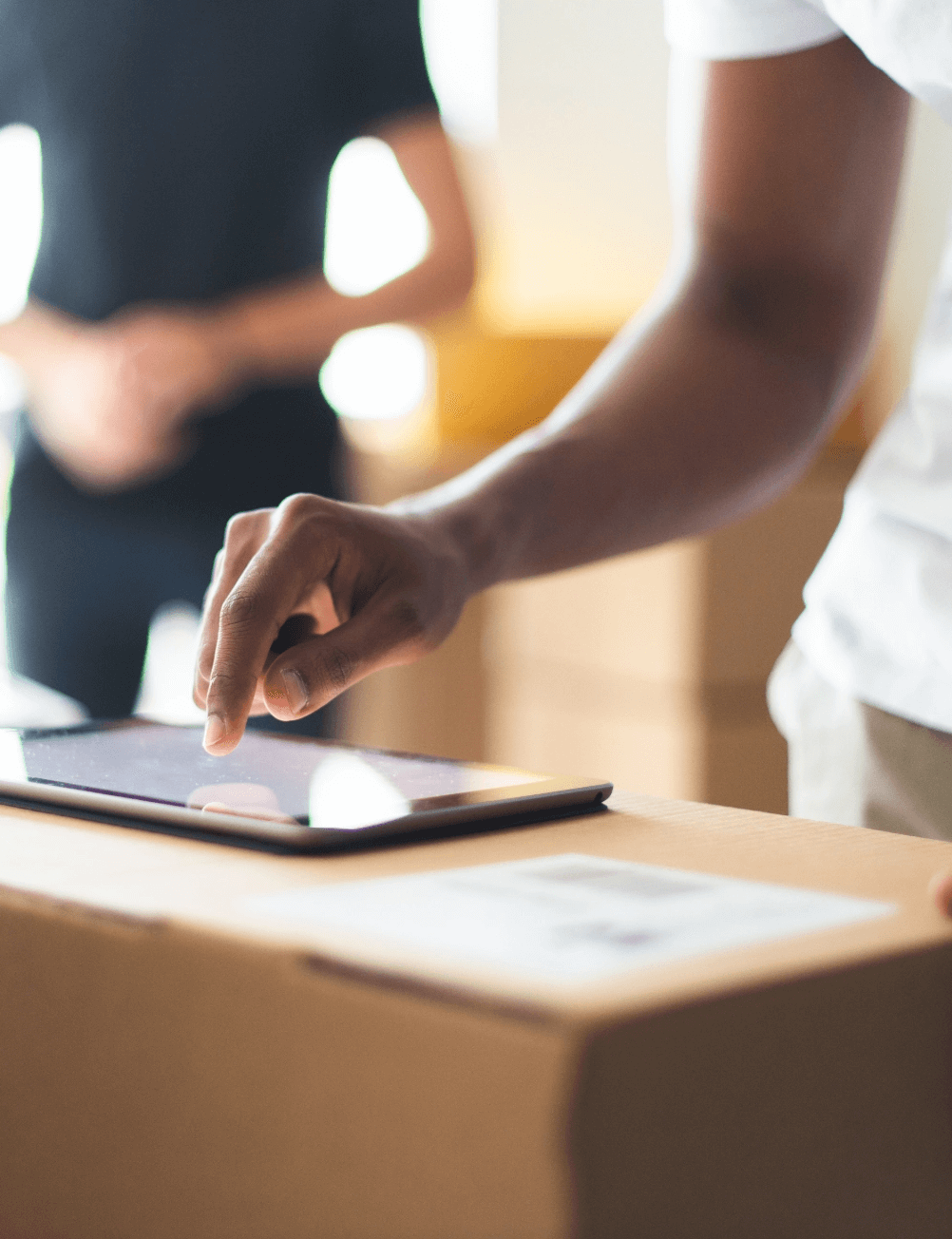 Person using a tablet on top of a box.