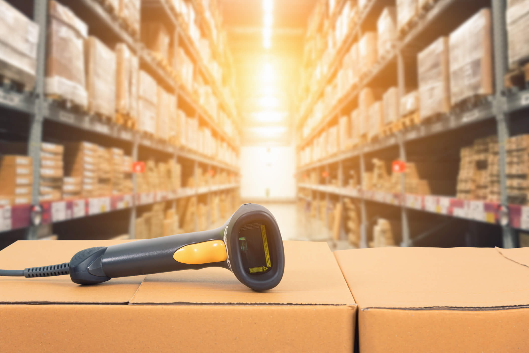 Shot of item scanner with warehouse aisle in background.