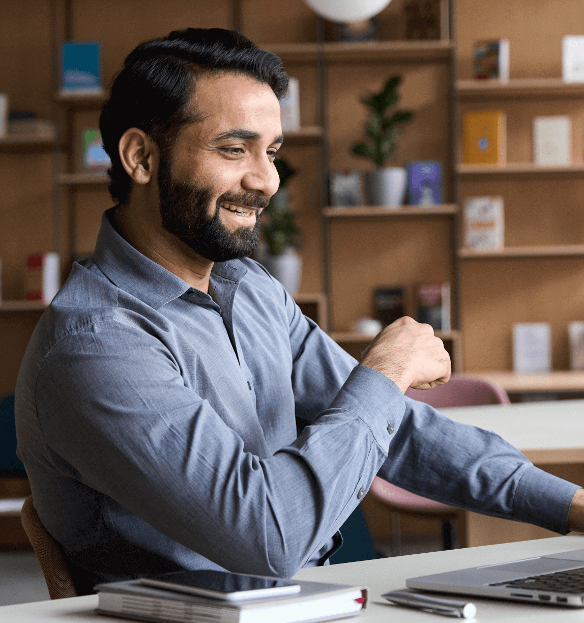 Man smiling and looking at a laptop.