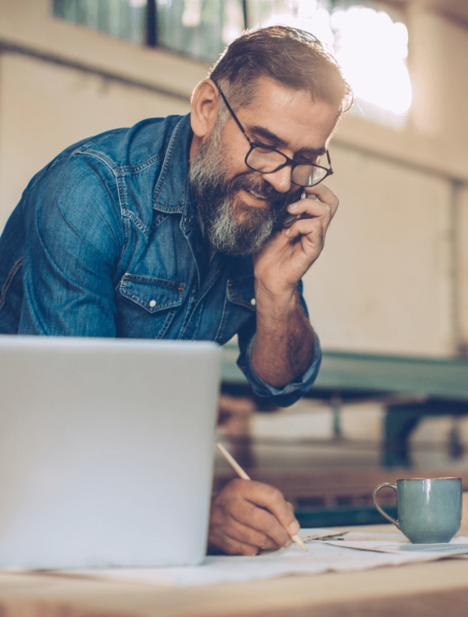 Image of a man on the phone and writing something down.