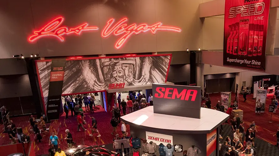 Arial shot of the SEMA conference floor with a large lit up Las Vegas sign.